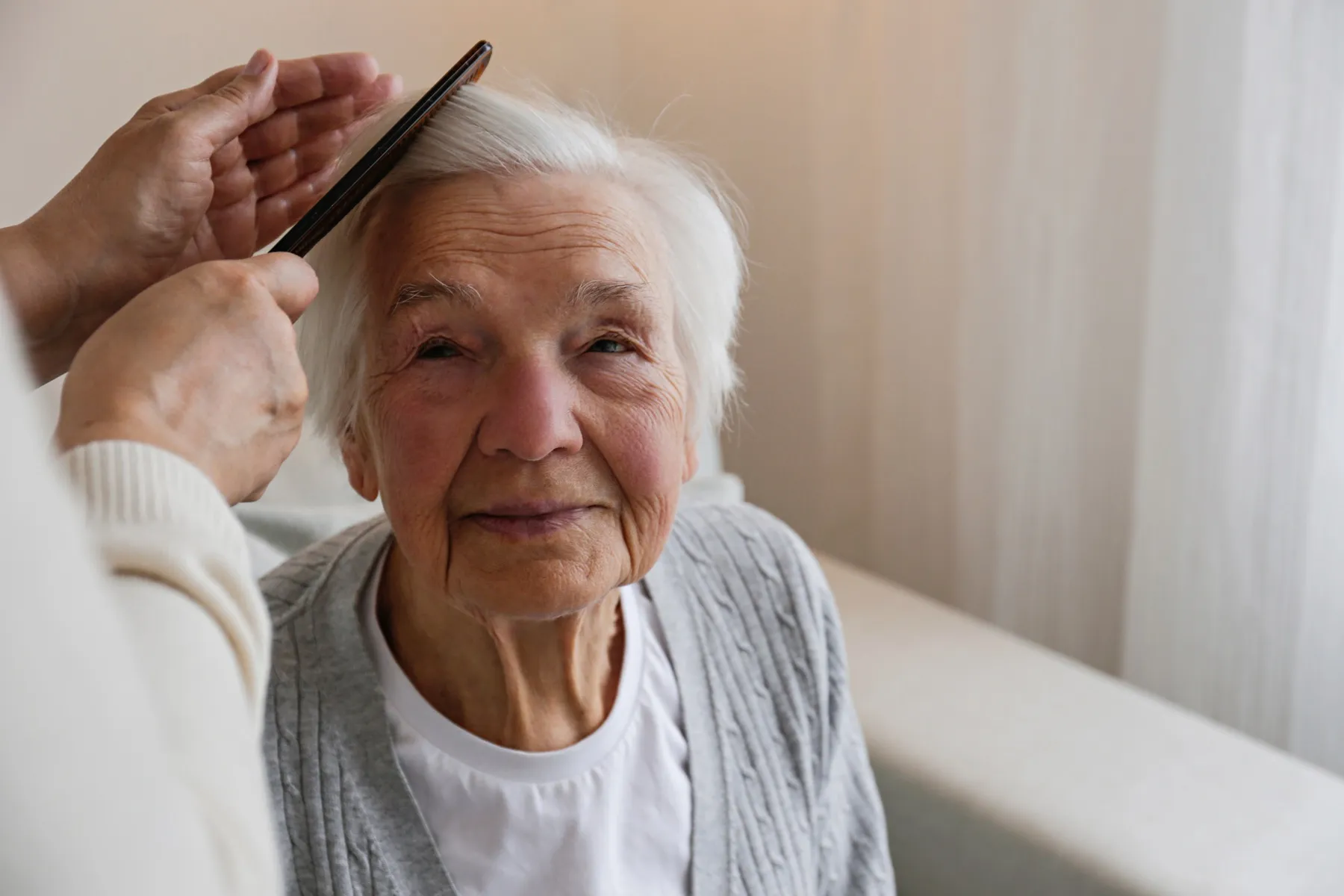 A caregiver providing gentle, attentive in-home care to a Northern Michigan senior